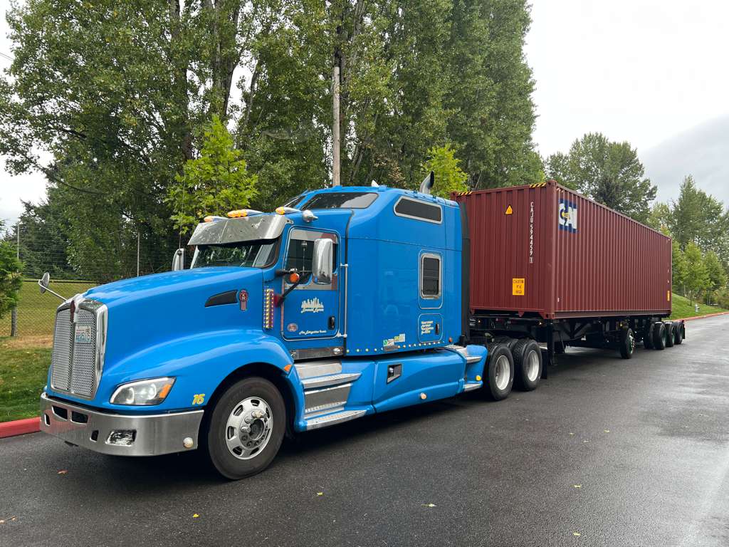 Emerald Express blue Kenworth T660 hauling a 40-foot container